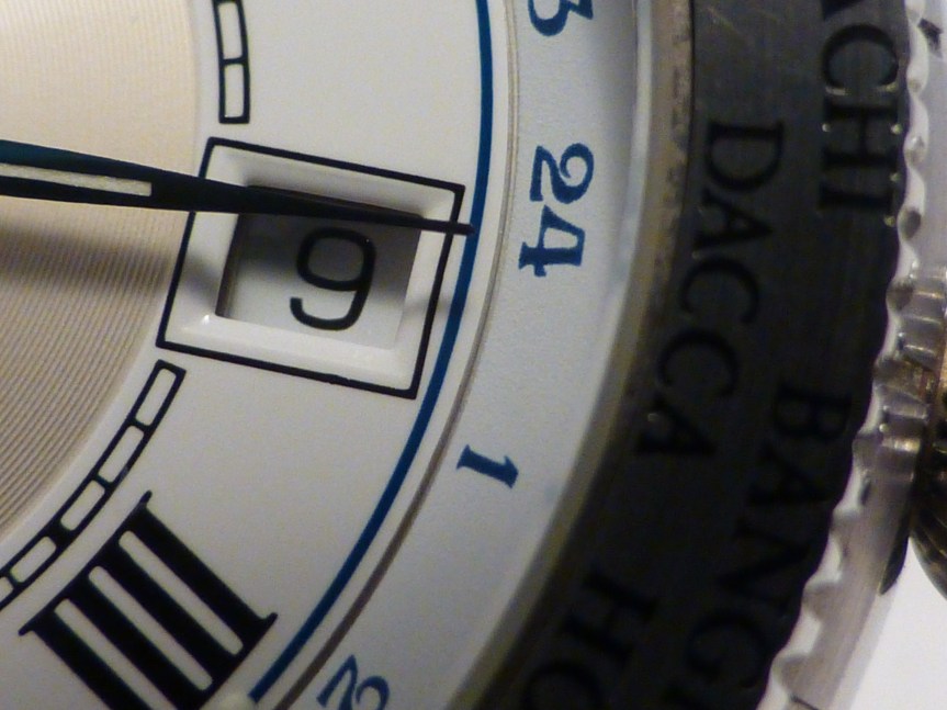 Curve cut enamel date window with GMT disc wheel outer index